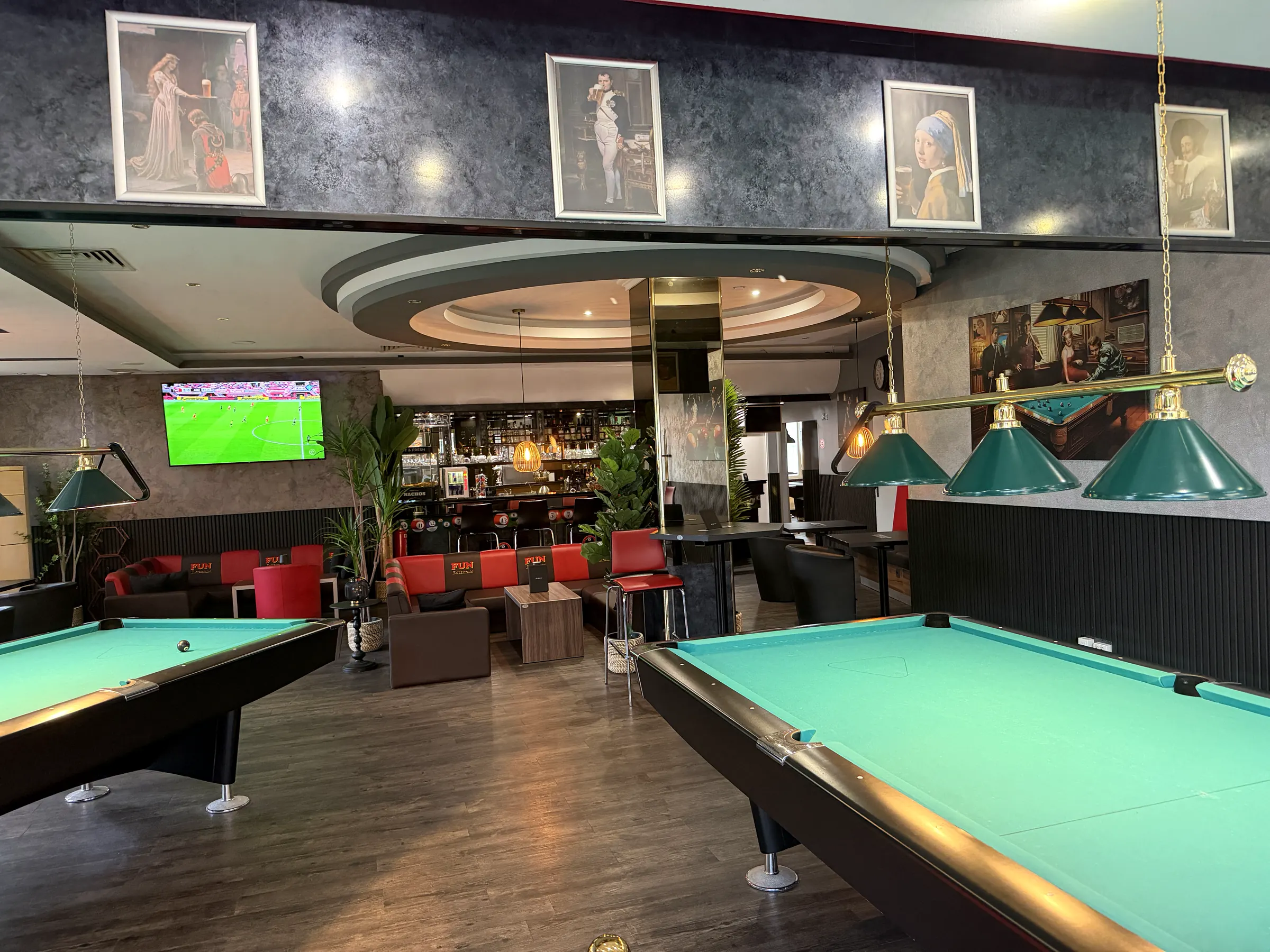 Poolbillardtische mit grünem Tuch in Dorsten, dahinter die Bar und der Sitzbereich